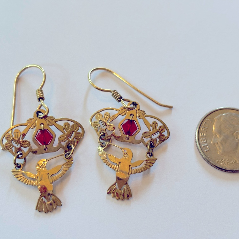 Wild Bryde gold hummingbird earrings with a red stone.